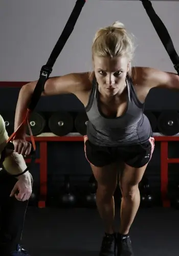 egzersiz halkalarıyla şınav çeken sarışın kadın